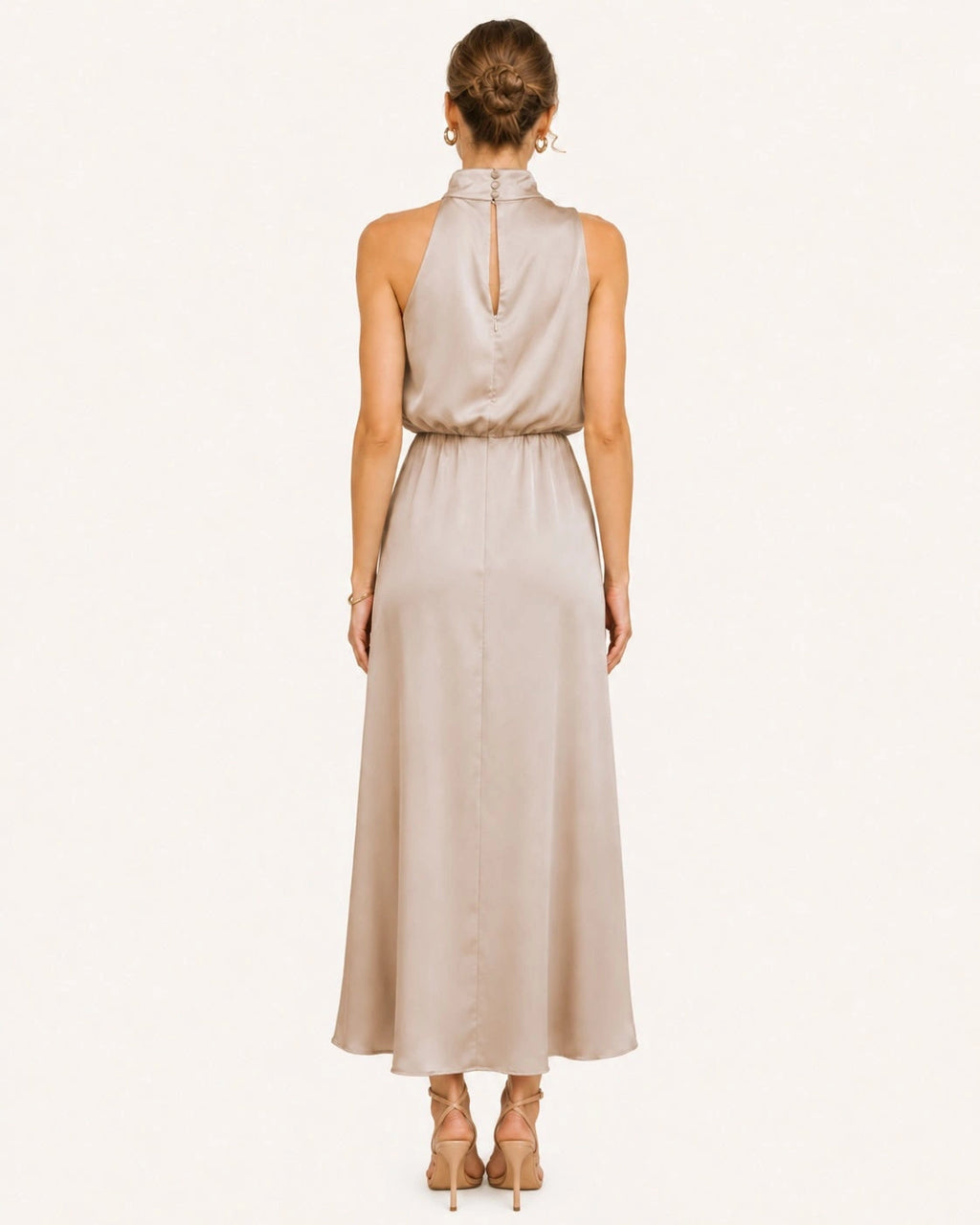 Dos d'une robe longue satinée champagne avec fermeture discrète au col et coupe fluide offrant une allure raffinée sous tous les angles. Vue dos.