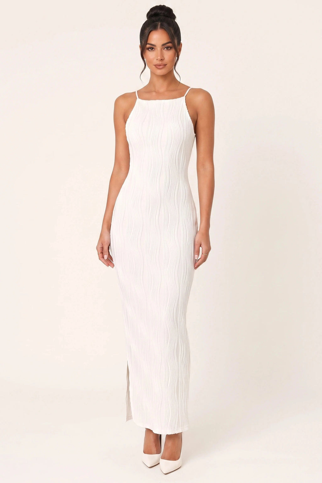 Robe moulante longue Maëlys blanche portée de face par le mannequin Diane Camille sur fond neutre clair, fines bretelles, texture plissée ondulée, coupe ajustée et fente discrète
