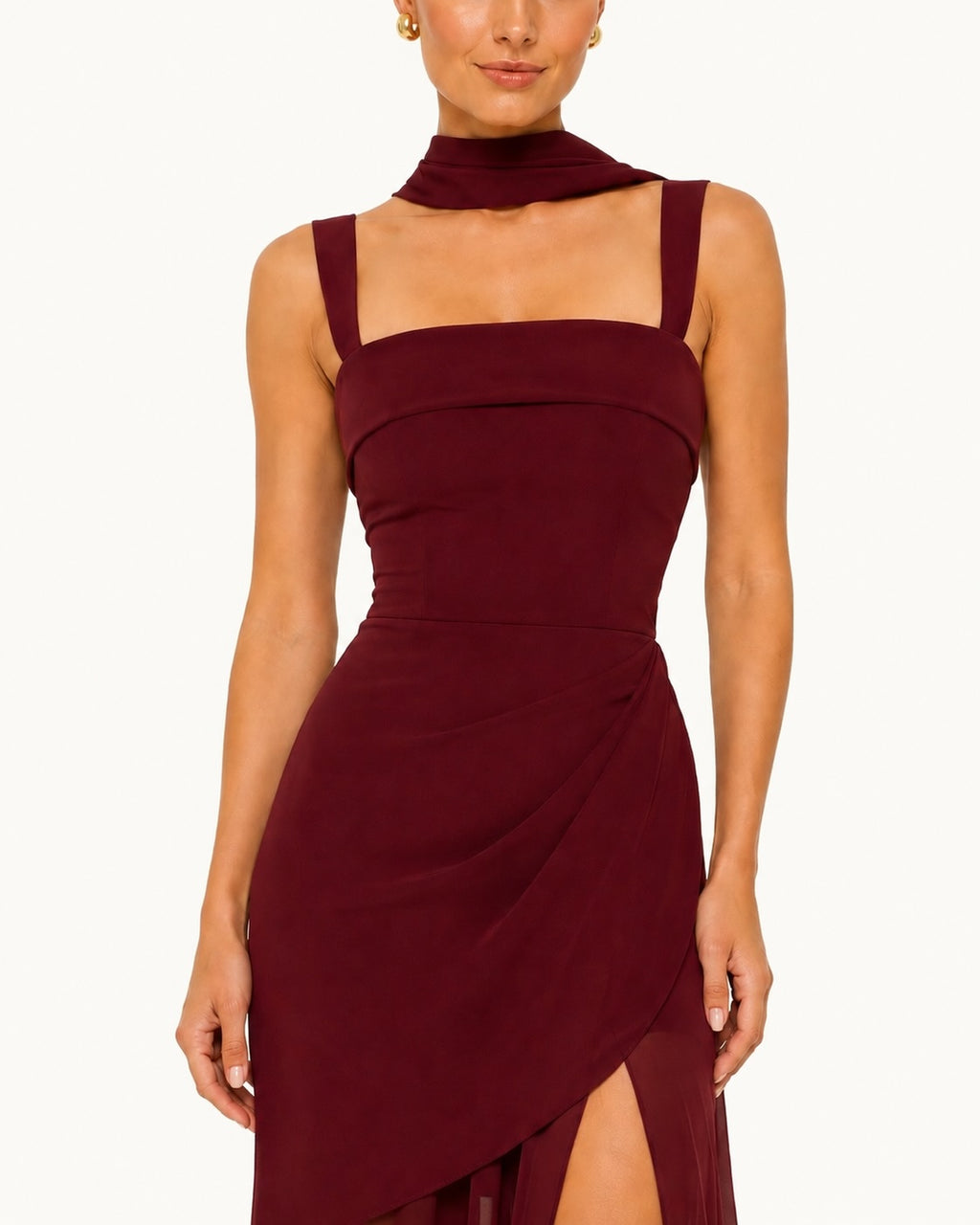 Zoom sur le bustier structuré d’une robe bordeaux élégante avec col drapé et détails couture, inspirée des tendances de la mode de cérémonie.
