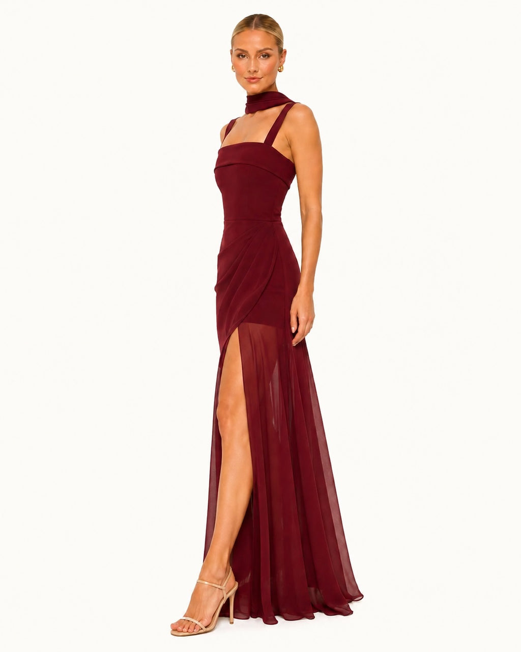 Robe de soirée bordeaux avec col foulard raffiné, coupe ajustée et fente sensuelle, sublimant la silhouette avec une allure sophistiquée.