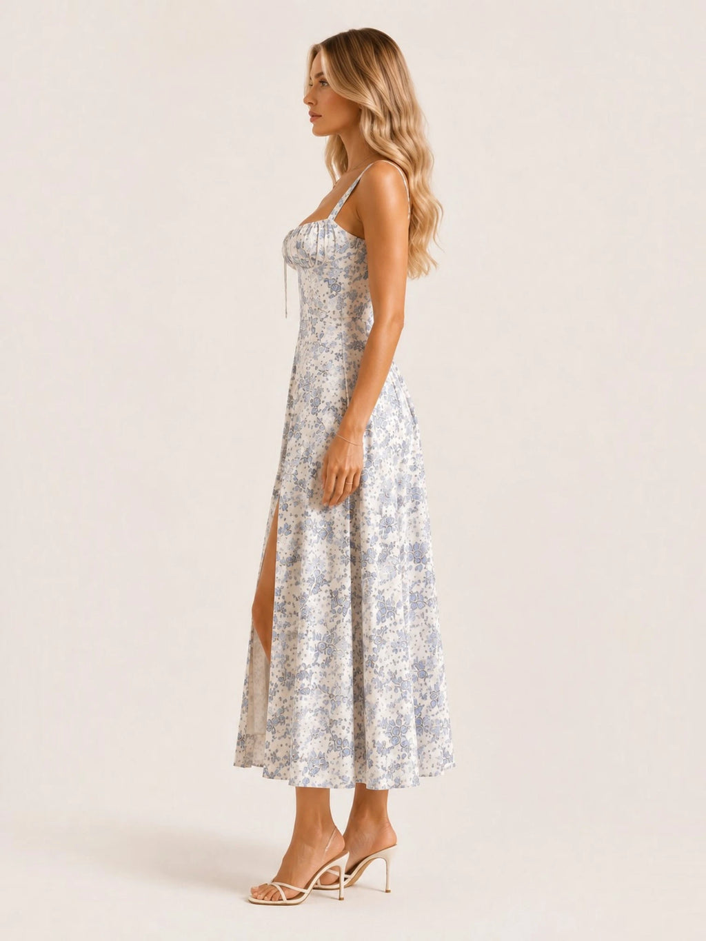 Profil de la robe midi fleurie à imprimé bleu et blanc avec coupe cintrée, corset structuré, fente latérale et silhouette féminine mettant en valeur la ligne du corps.