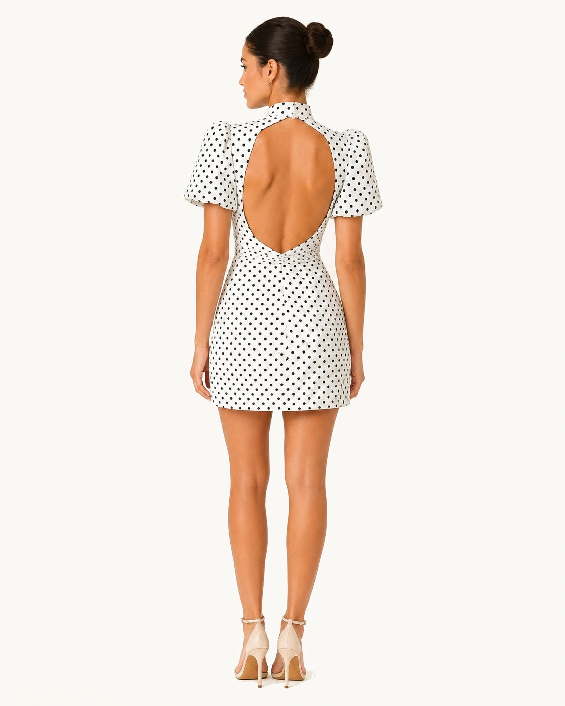 Vue complète de dos de la robe courte Stella blanche à pois noirs avec dos nu plongeant, manches bouffantes et coupe ajustée, idéale pour un look chic et tendance.