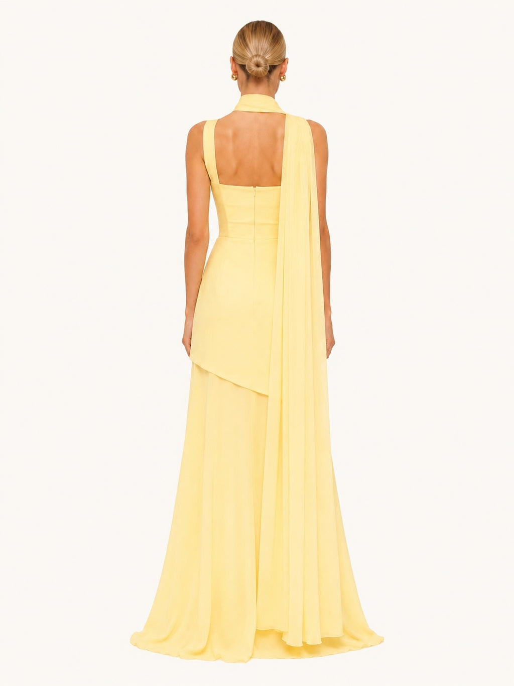 Dos d’une robe longue jaune pastel avec voile fluide et détail foulard tombant, parfaite pour une tenue de cérémonie sophistiquée et romantique.
