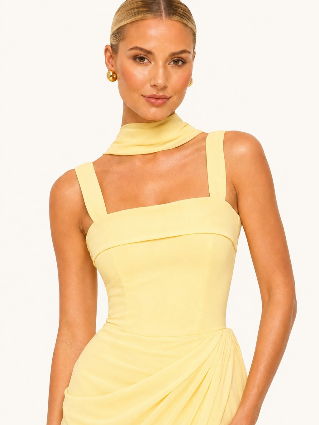 Zoom sur le bustier structuré d’une robe jaune pâle à encolure carrée et col drapé, alliant élégance contemporaine et raffinement féminin.