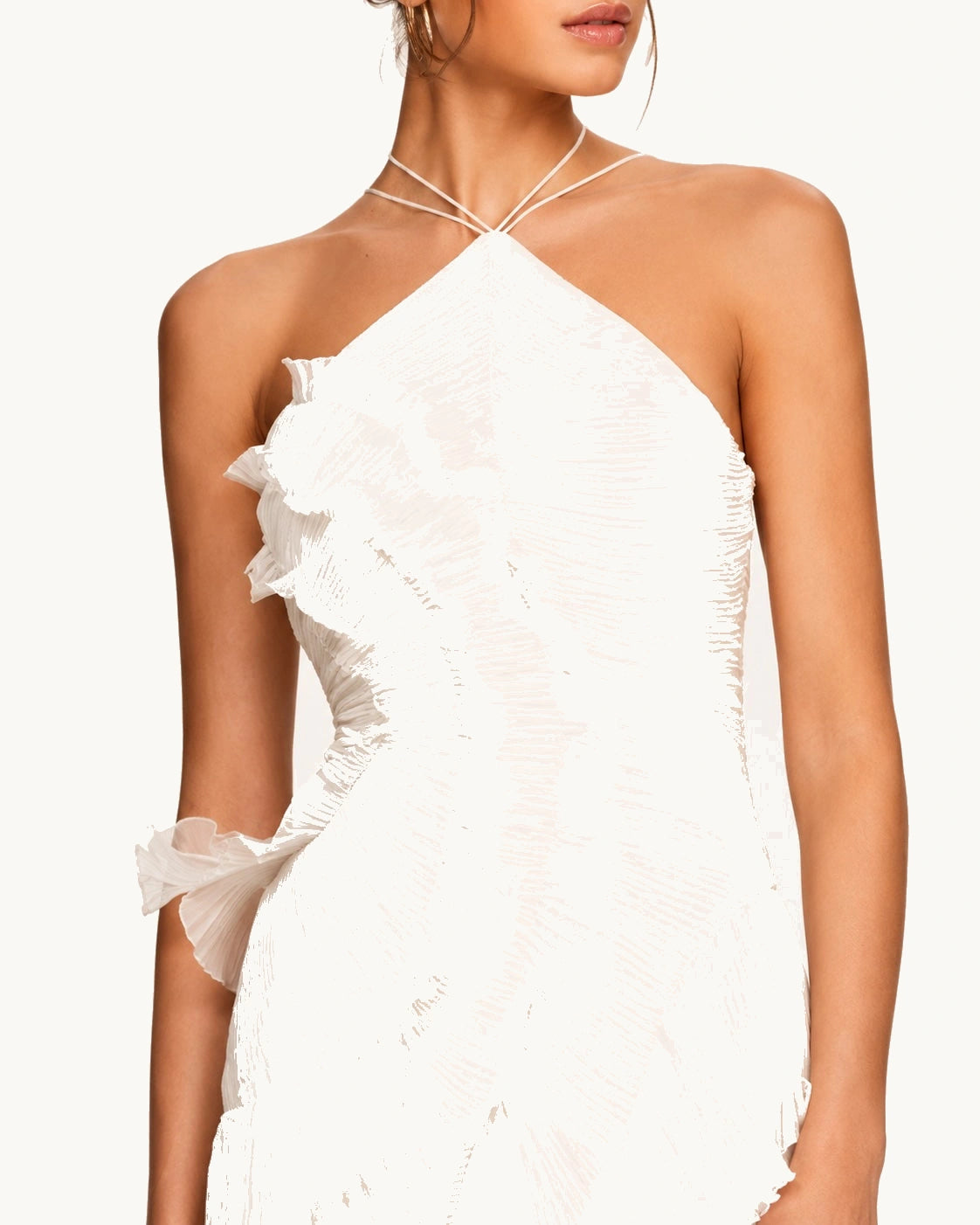 Détail du bustier plissé blanc à encolure croisée, sublimé par des volants délicats qui apportent relief, mouvement et féminité à cette robe de cérémonie.