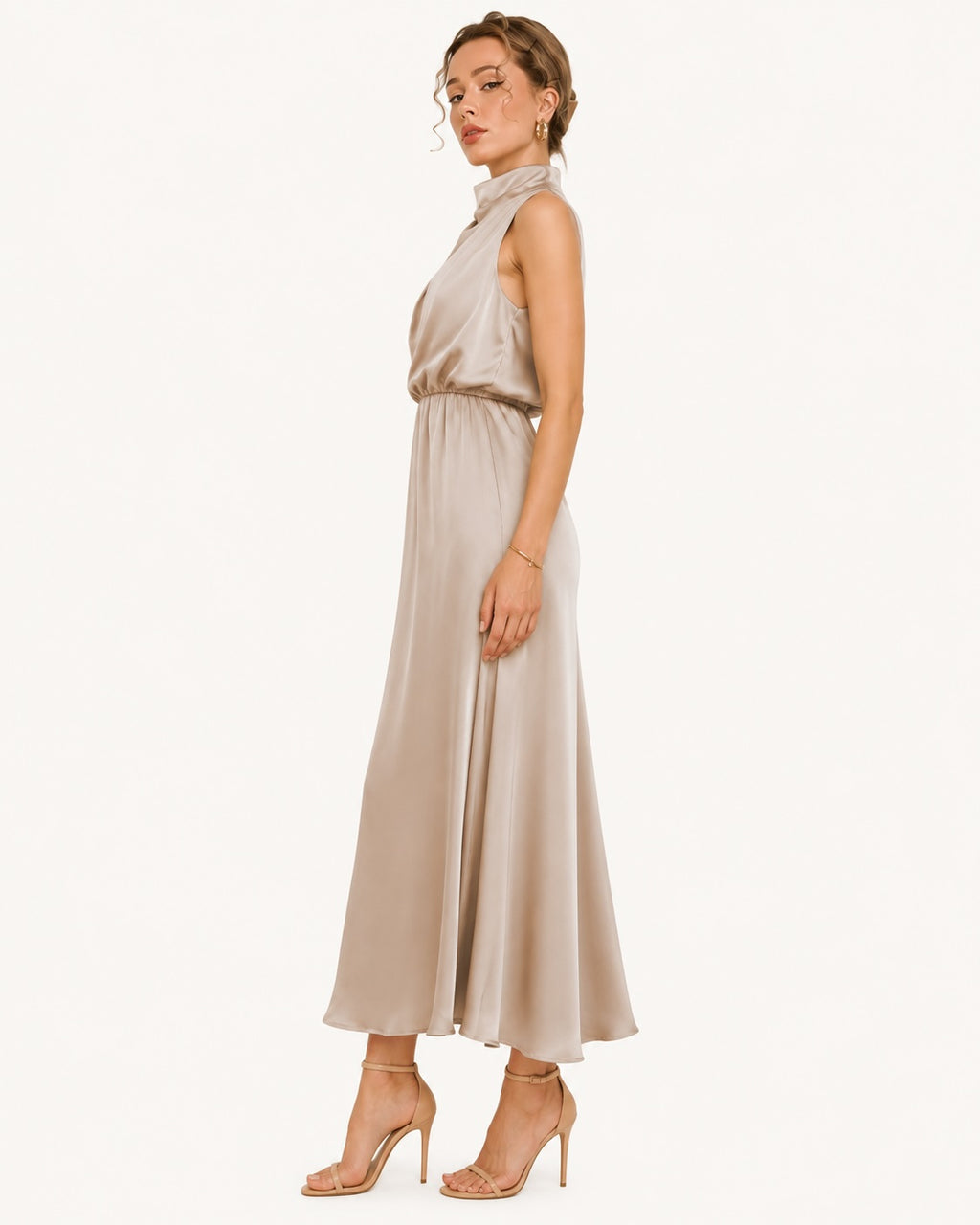 Robe longue champagne en satin vue de profil, coupe fluide et silhouette élancée idéale pour un mariage, une réception ou une soirée habillée. Vue de profil.