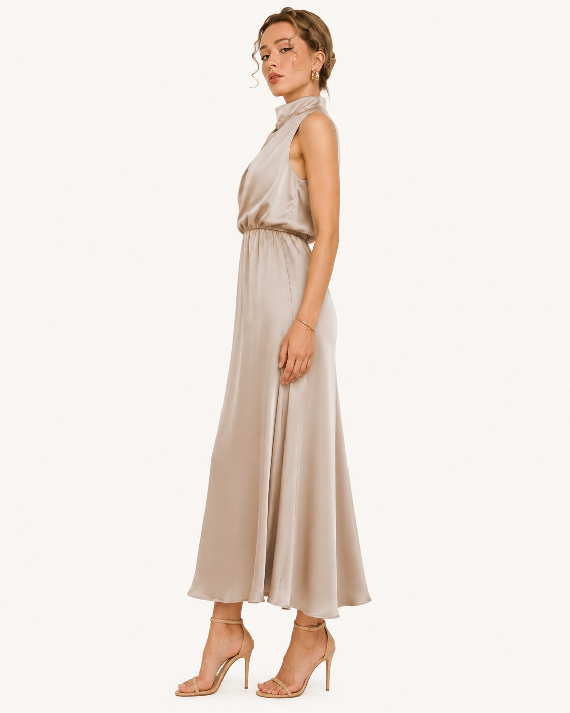 Robe longue champagne en satin vue de profil, coupe fluide et silhouette élancée idéale pour un mariage, une réception ou une soirée habillée. Vue de profil.