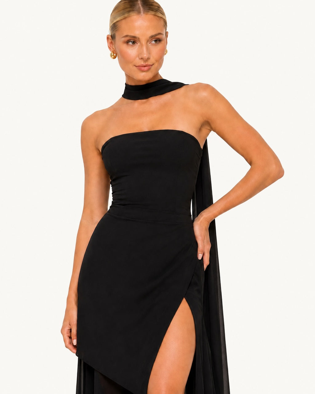 Détail du haut d'une robe noire de soirée avec col foulard satiné, coupe bustier moderne et finition haut de gamme au style résolument sophistiqué. Gros plan du buste.