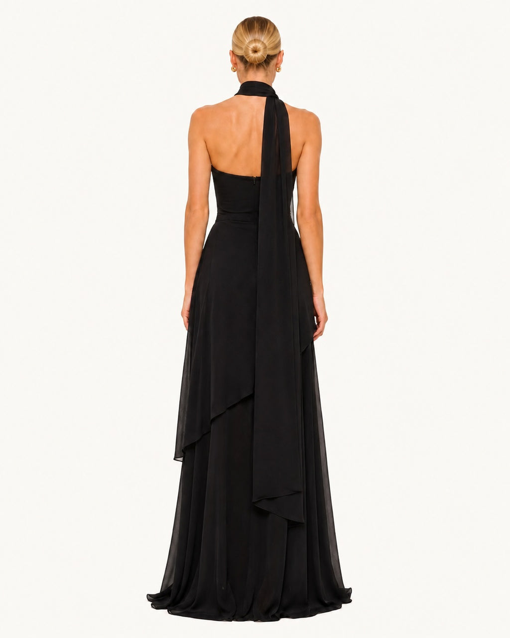 Dos d'une robe longue noire avec voile transparent tombant depuis le col, finition raffinée et allure majestueuse pour les grandes occasions.