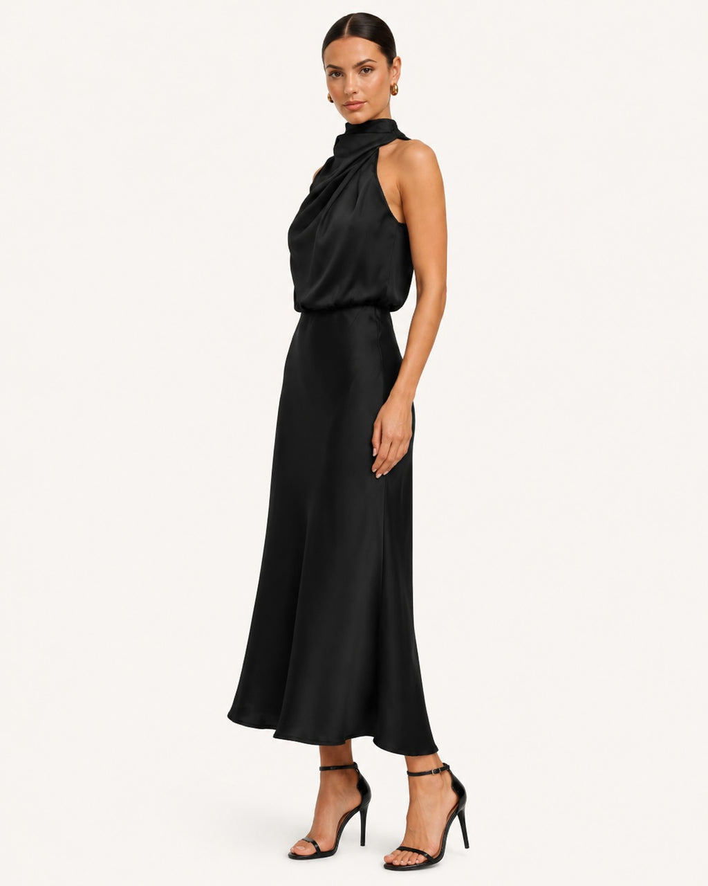Profil d’une robe noire satinée à col haut drapé et coupe évasée, offrant une silhouette élancée et une élégance intemporelle.