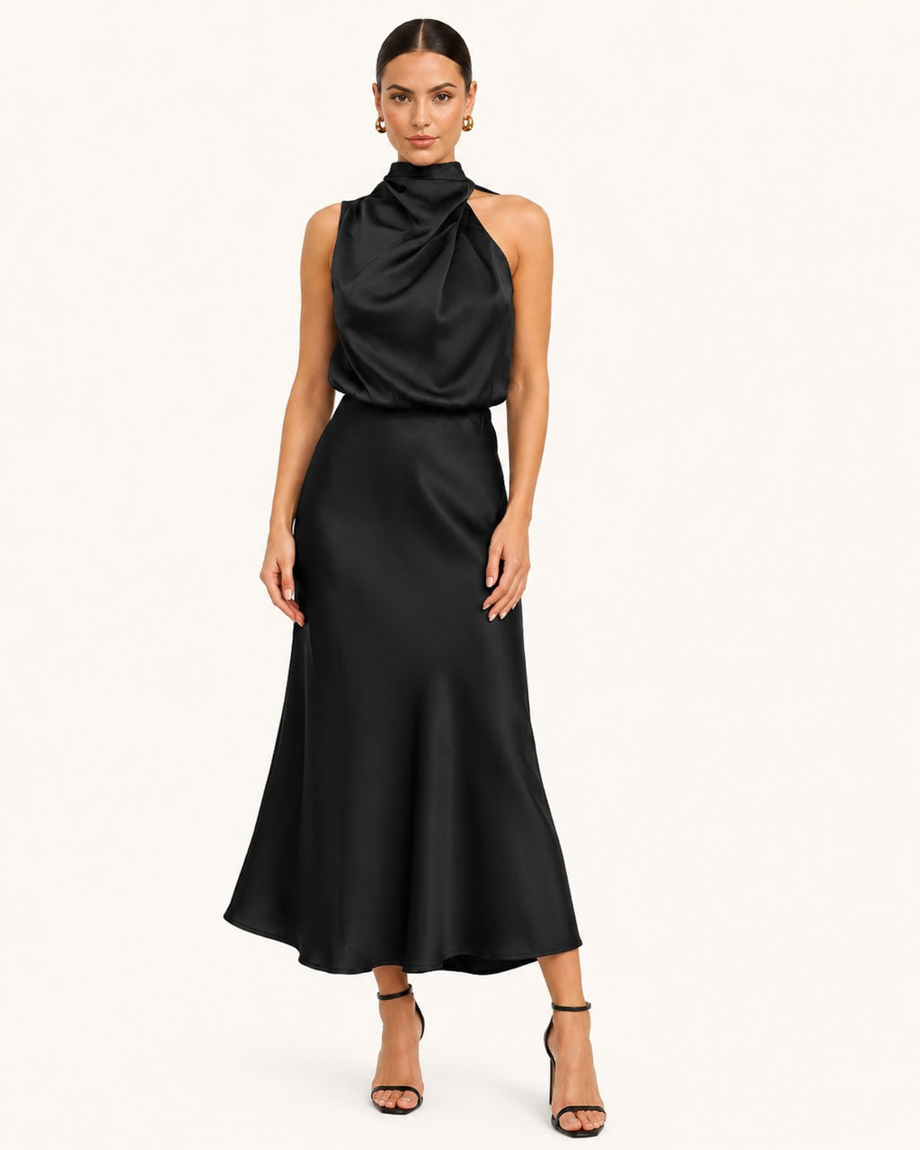 Robe noire élégante longueur midi avec col montant asymétrique drapé, coupe fluide et silhouette féminine pour cérémonie ou réception.