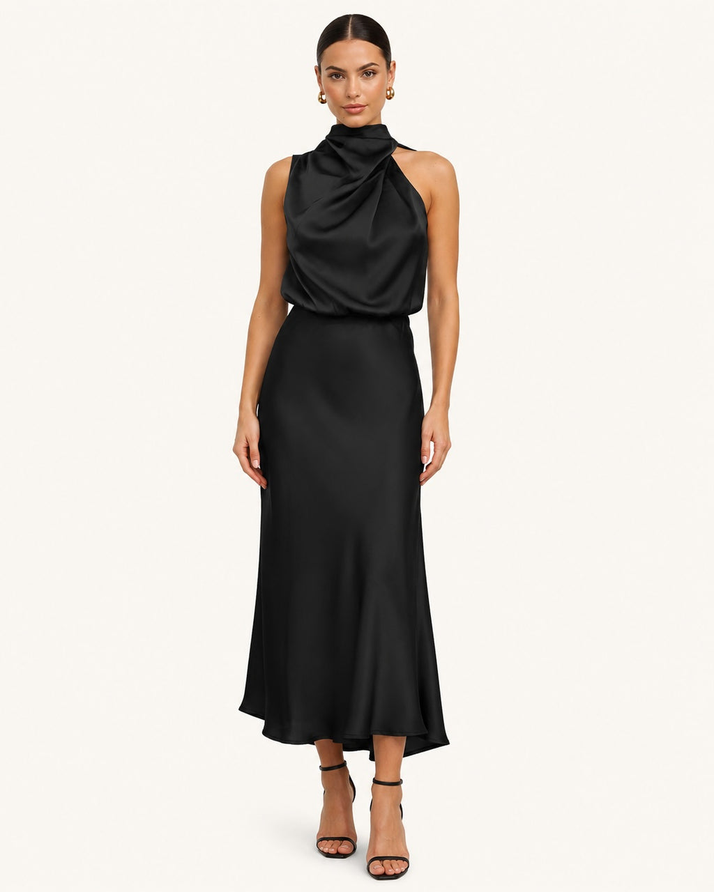 Robe noire élégante longueur midi avec col montant asymétrique drapé, coupe fluide et silhouette féminine pour cérémonie ou réception.