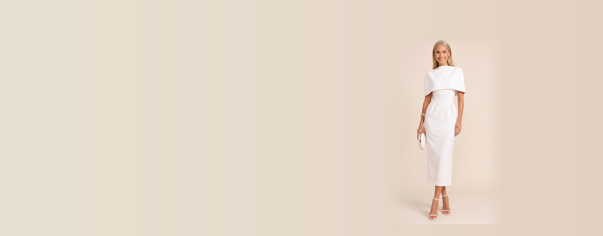 Robe tailleur blanche Alice, coupe midi et cape structurée, portée de face sur fond beige ivoire
