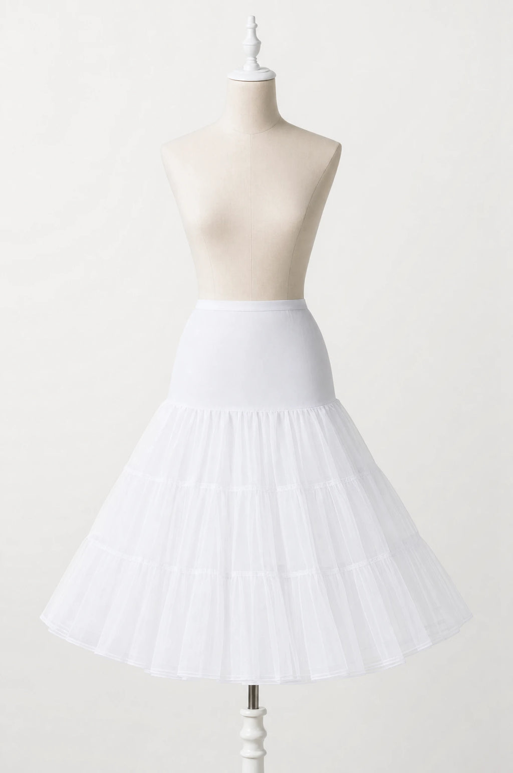 Jupon crinoline blanc vintage à volants seul sur mannequin buste, trois volants superposés en tulle rigide, taille élastiquée, longueur genou