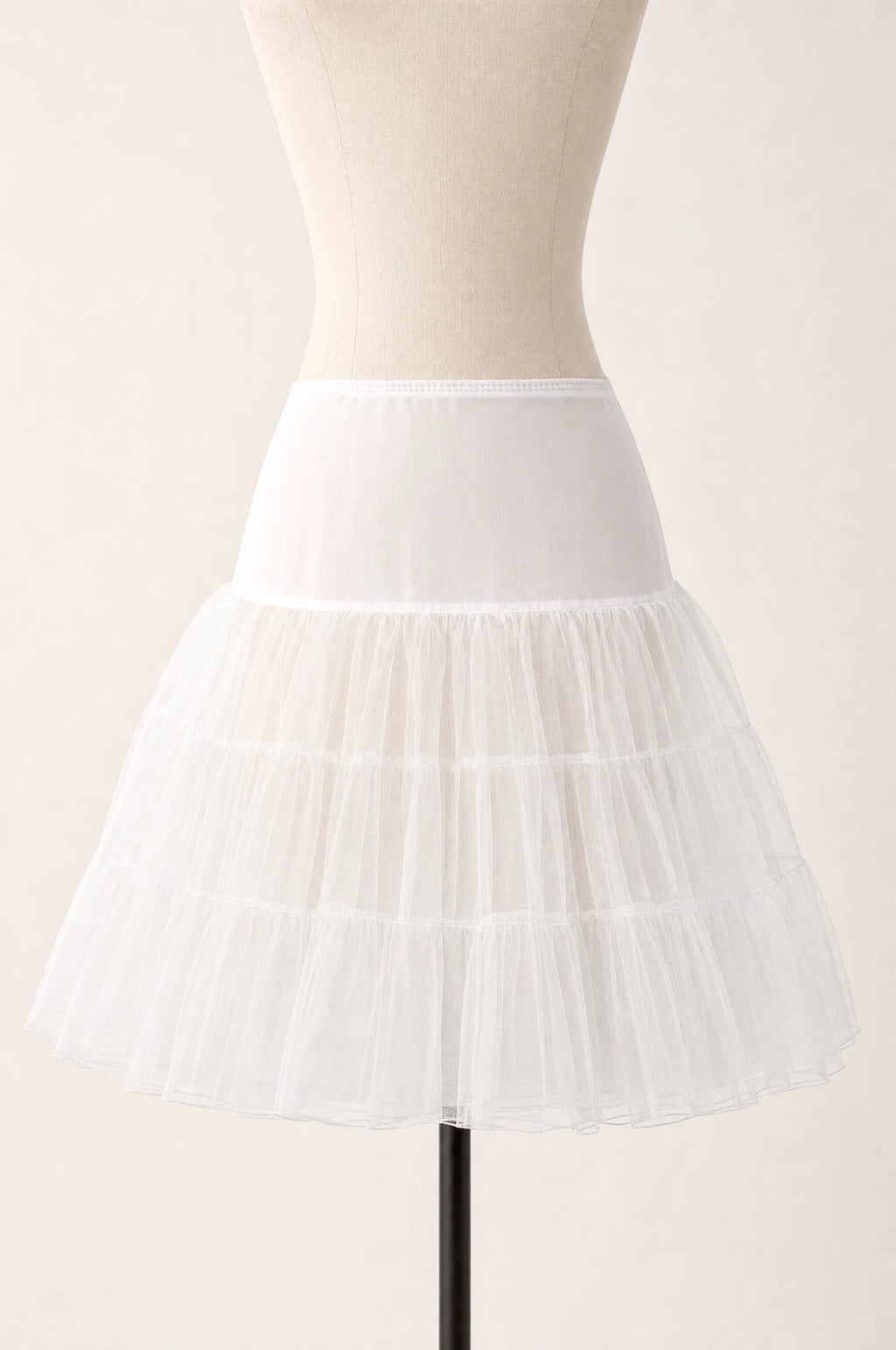 Jupon crinoline ivoire vintage à volants seul sur mannequin buste, trois volants superposés en tulle rigide, taille élastiquée, longueur genou
