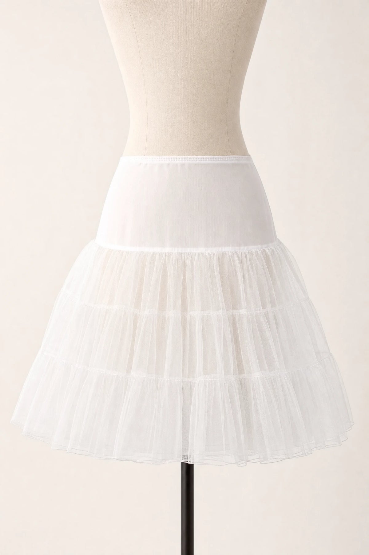 Jupon crinoline ivoire vintage à volants seul sur mannequin buste, trois volants superposés en tulle rigide, taille élastiquée, longueur genou