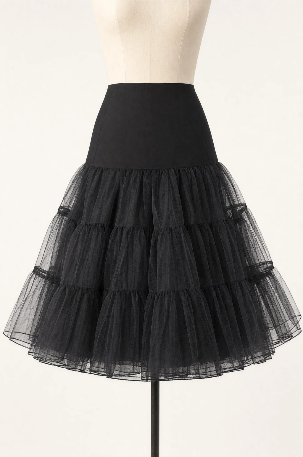 Jupon crinoline noir vintage à volants seul sur mannequin buste, trois volants superposés en tulle rigide, taille élastiquée, longueur genou