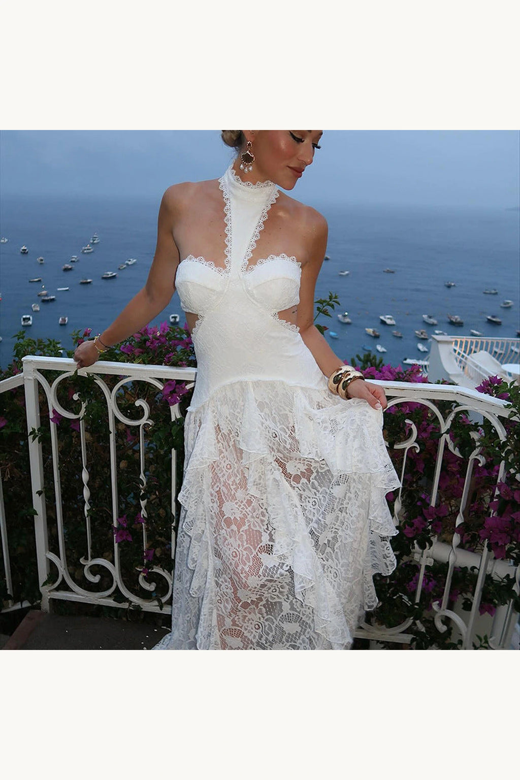 Robe bohème blanche longue en dentelle Sienna sur balcon face mer, col halter, bustier et jupe transparente pour une allure bohème chic