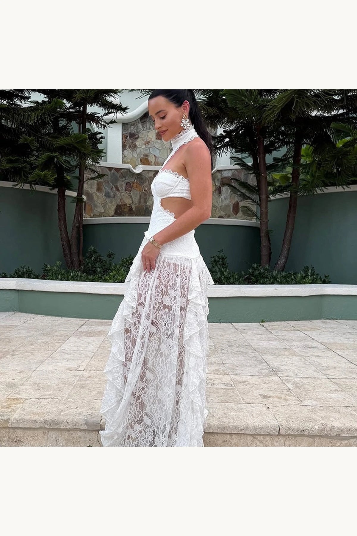 Robe bohème longue dentelle Sienna blanche vue de profil, découpes latérales, bustier structuré et jupe transparente en dentelle ajourée