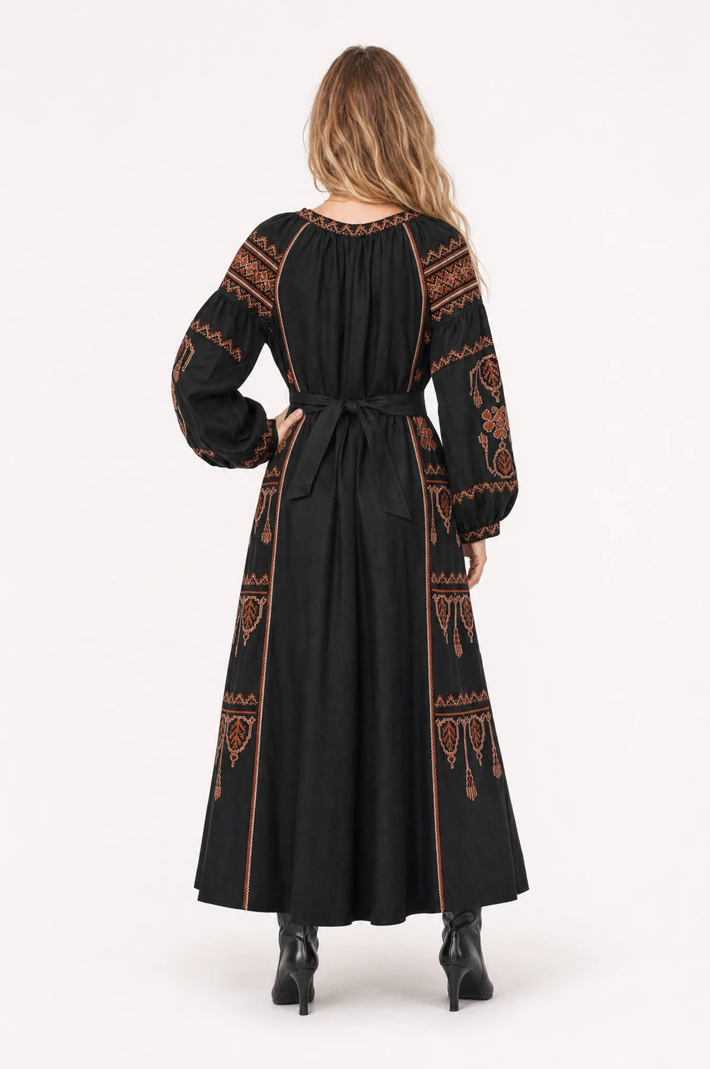 Robe bohème brodée noire Salomé portée de dos par Aude, panneaux brodés ethniques rouille et terracotta sur les épaules et les manches, ceinture nouée dans le dos, jupe évasée fluide jusqu'aux chevilles