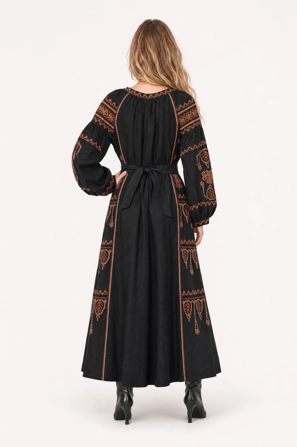 Robe bohème brodée noire Salomé portée de dos par Aude, panneaux brodés ethniques rouille et terracotta sur les épaules et les manches, ceinture nouée dans le dos, jupe évasée fluide jusqu'aux chevilles
