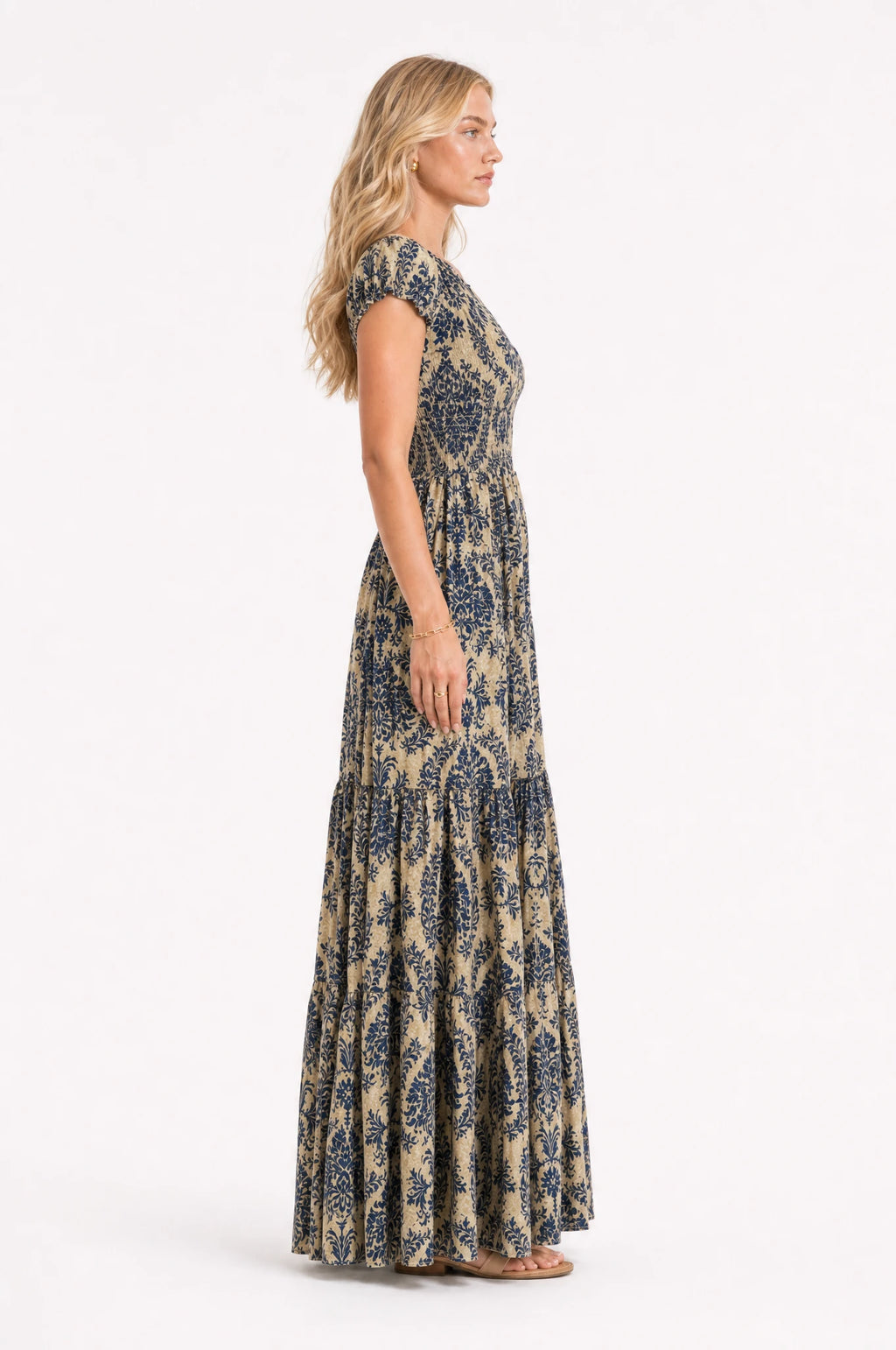 Robe bohème longue fleurie Océane vue de profil portée par Sophie cheveux détachés, silhouette fluide et taille froncée, jupe longue à volants jusqu'au sol, coupe ample bohème chic