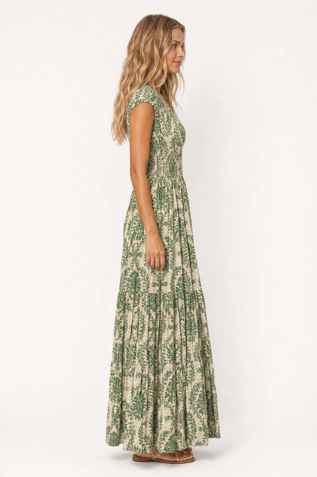 Robe bohème longue fleurie Capucine vue de profil portée par Aude, silhouette fluide et taille froncée, jupe longue à volants jusqu'au sol, coupe ample bohème chic