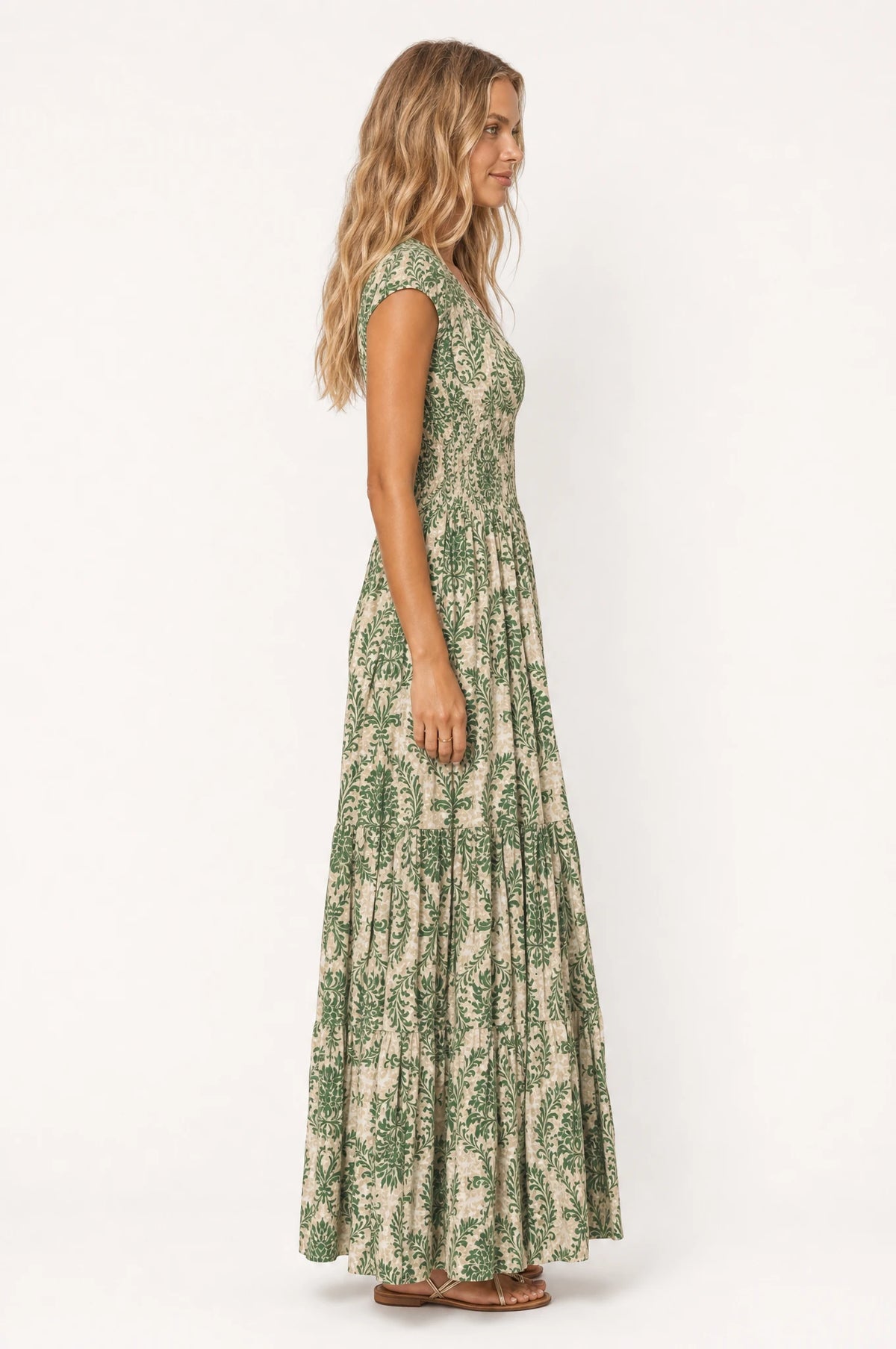 Robe bohème longue fleurie Capucine vue de profil portée par Aude, silhouette fluide et taille froncée, jupe longue à volants jusqu'au sol, coupe ample bohème chic