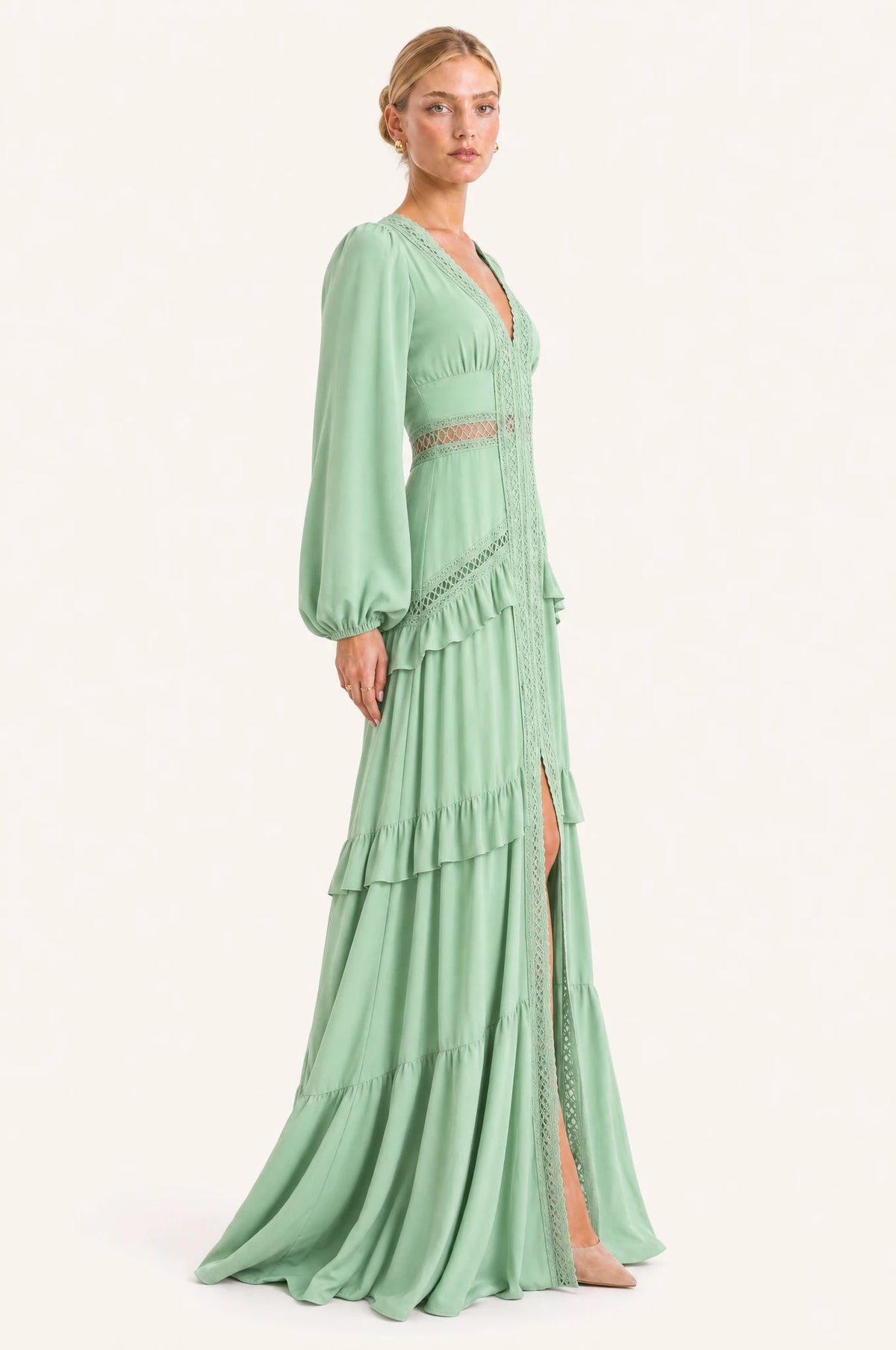 Robe bohème longue vert clair Ondine vue de profil portée par Sophie, taille empire marquée par la dentelle, jupe à volants superposés longueur au sol