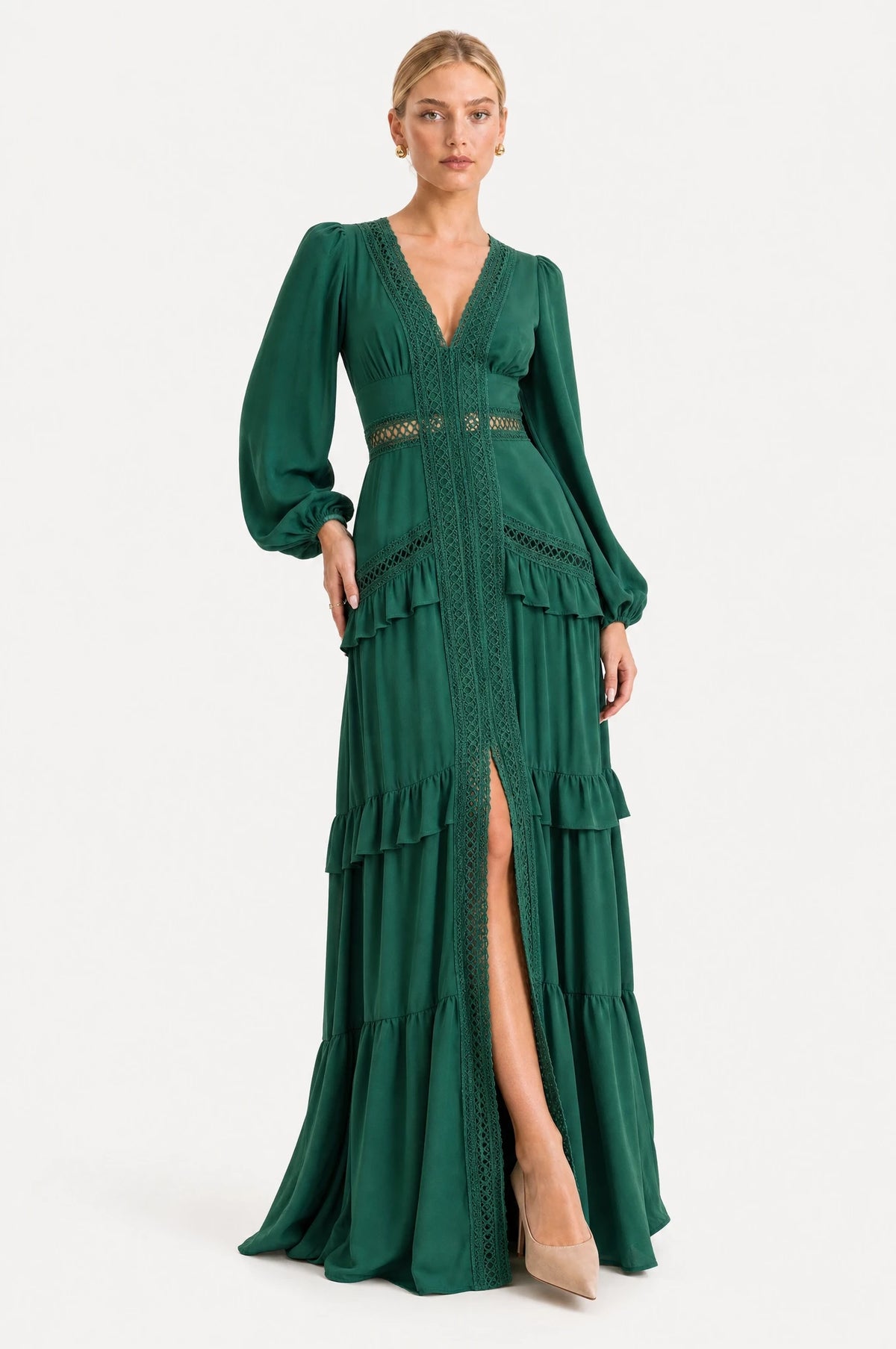 Robe bohème longue verte Ondine portée de face par Sophie chignon bas sleek, décolleté en V profond bordé de dentelle ajourée, manches longues bouffantes, large bande de dentelle à la taille empire, jupe à volants superposés avec fente devant