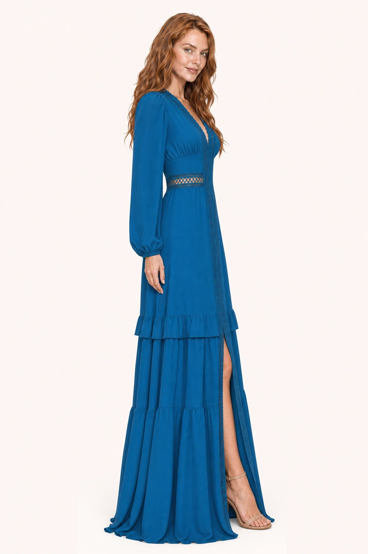 Robe bohème longue bleue Perrine vue de profil portée par Julie, taille empire marquée par une bande de dentelle ajourée laissant voir la peau, jupe à volants superposés avec fente devant, longueur au sol