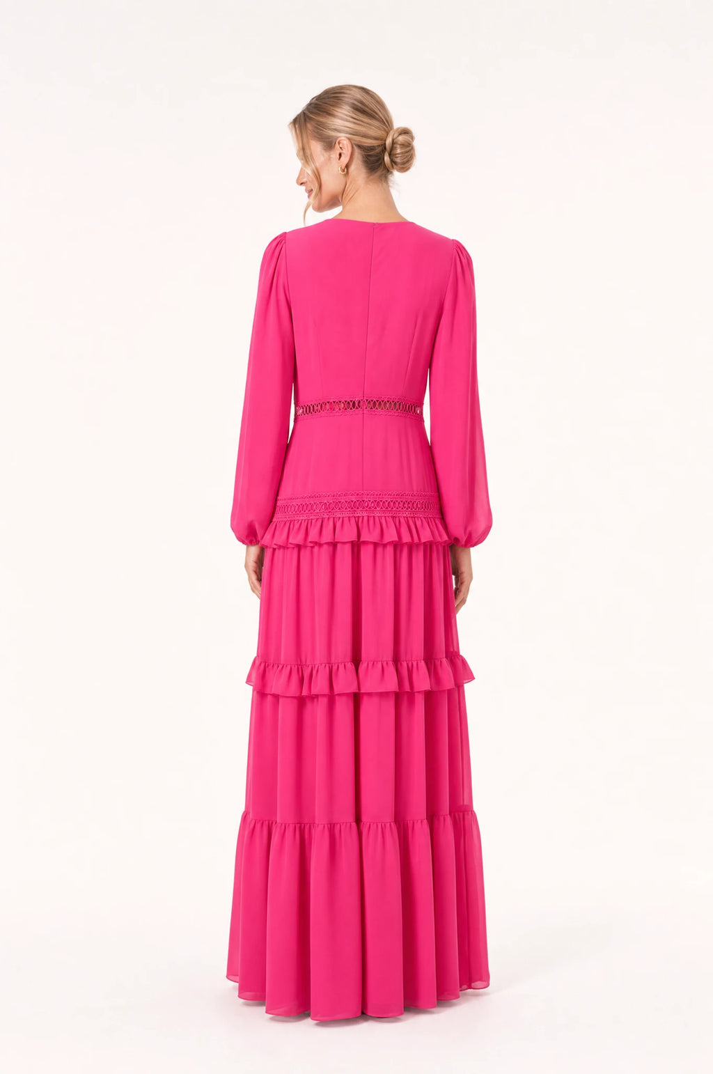 Dos de la robe bohème longue rose Séraphine portée par Aude, dos uni avec couture centrale discrète, manches longues bouffantes, jupe à volants superposés, longueur au sol