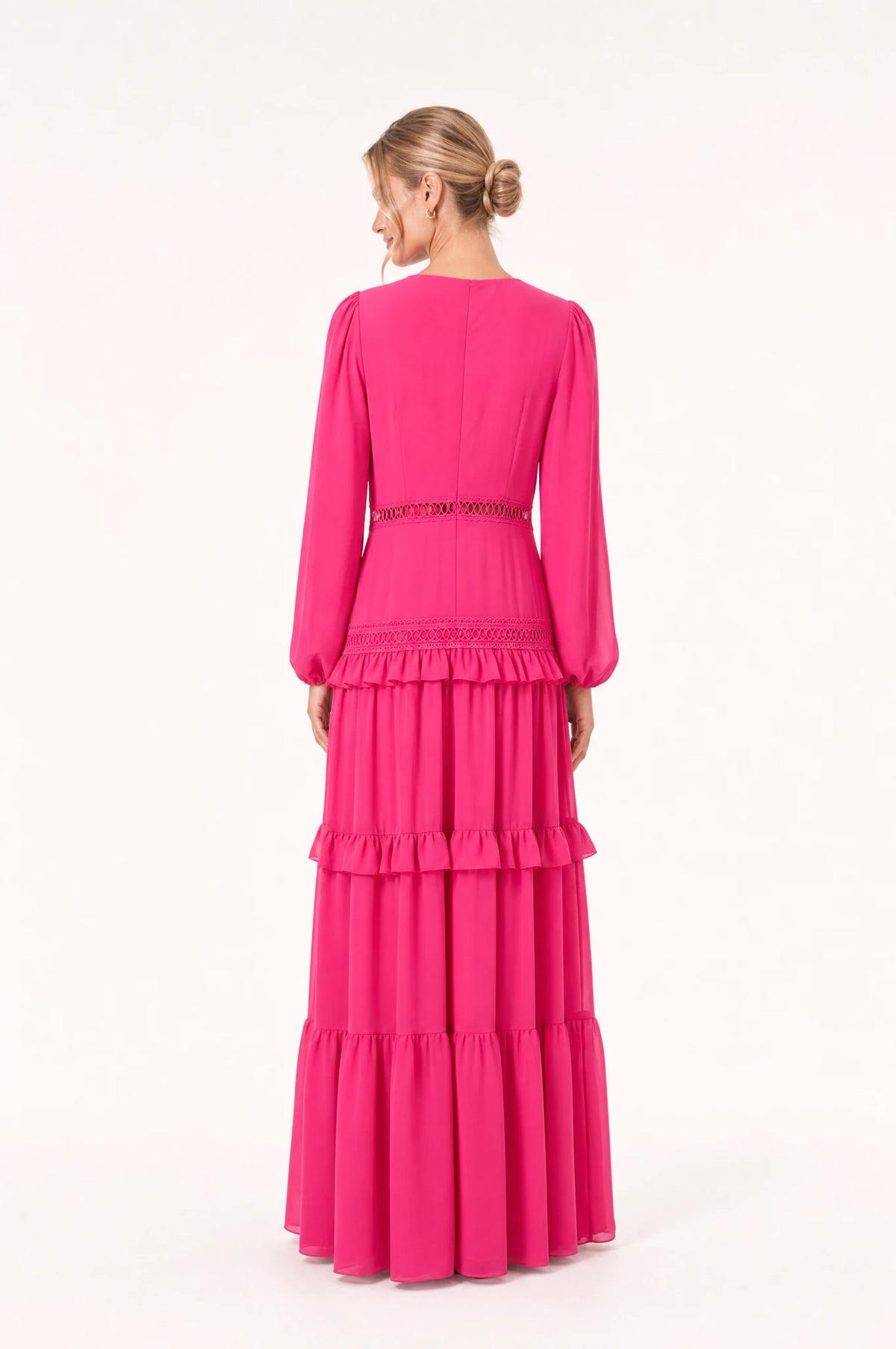Dos de la robe bohème longue rose Séraphine portée par Aude, dos uni avec couture centrale discrète, manches longues bouffantes, jupe à volants superposés, longueur au sol