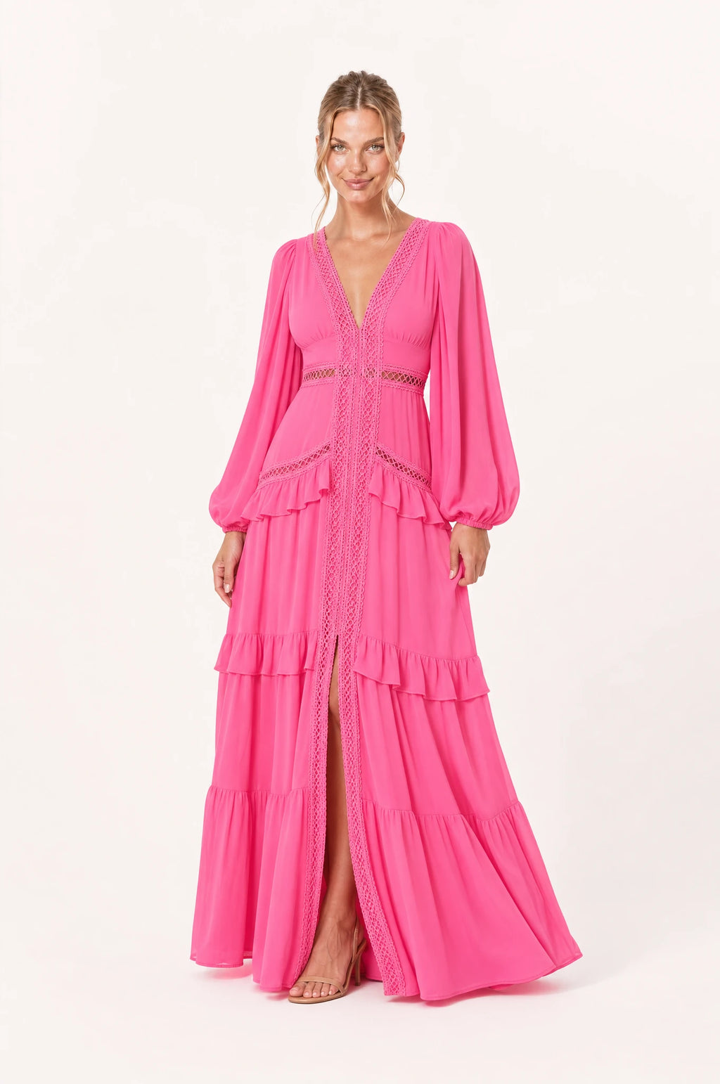 Robe bohème longue rose Séraphine portée de face par Aude, décolleté en V profond bordé de dentelle ajourée, galon tressé central, bande de dentelle ajourée à la taille empire, manches longues bouffantes, jupe à volants superposés avec fente devant