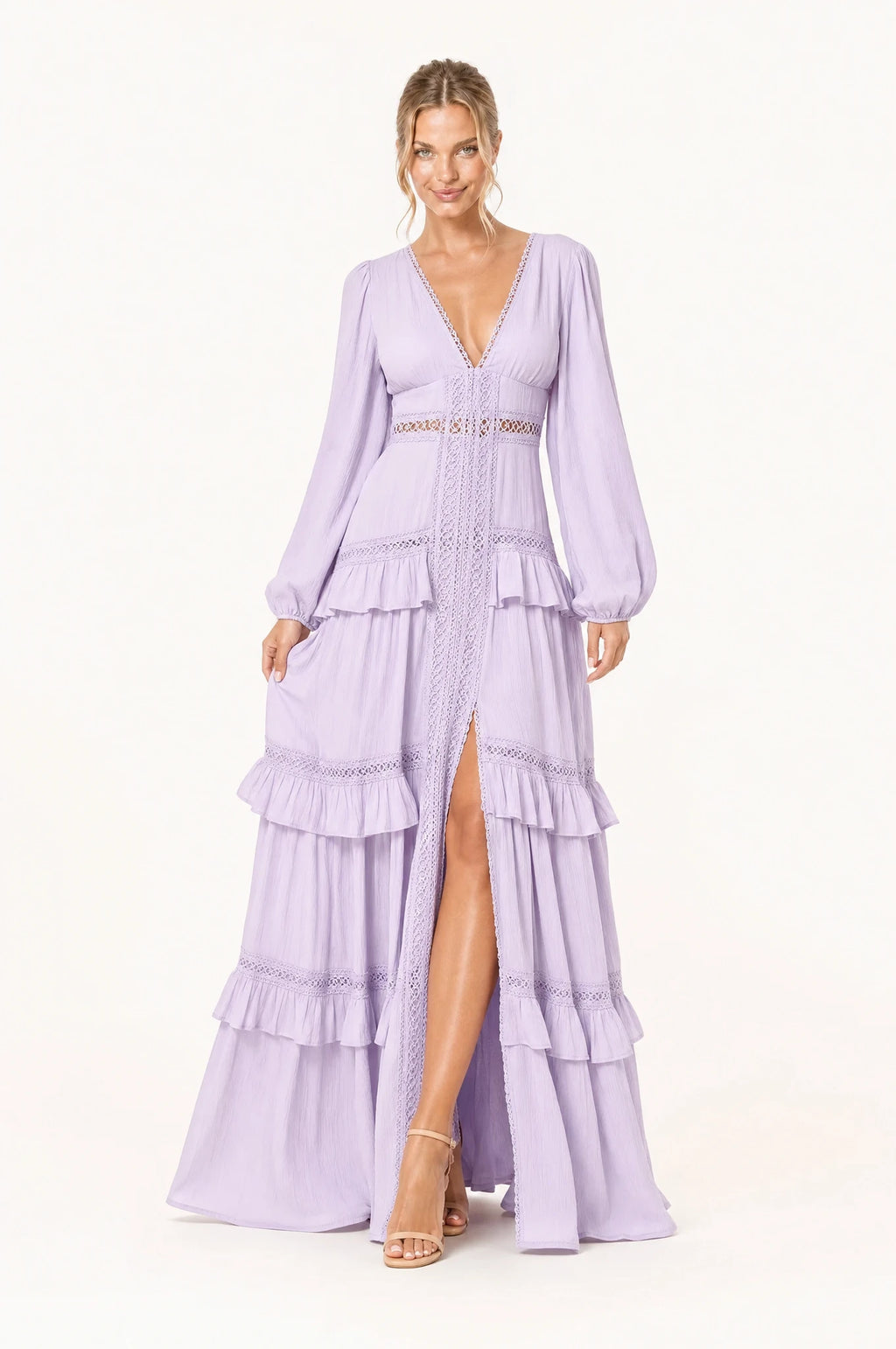 Robe bohème longue violette Séraphine portée de face par Aude chignon bas sleek, décolleté en V profond bordé de dentelle ajourée, galon tressé central, bande de dentelle ajourée à la taille empire, manches longues bouffantes, jupe à volants superposés avec fente devant