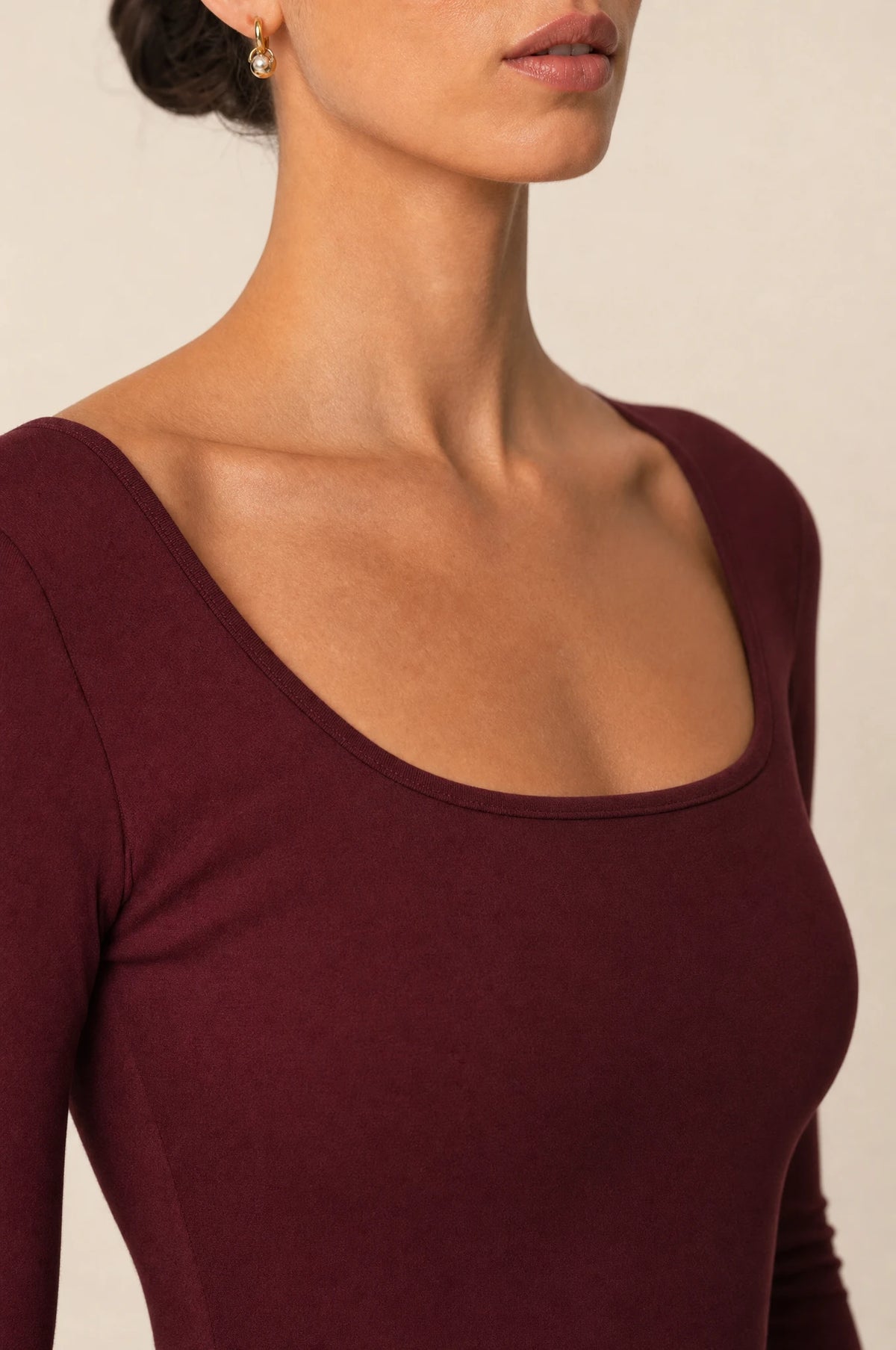 Gros plan encolure carrée et tissu lisse de la robe bordeaux moulante Louise, détail couture