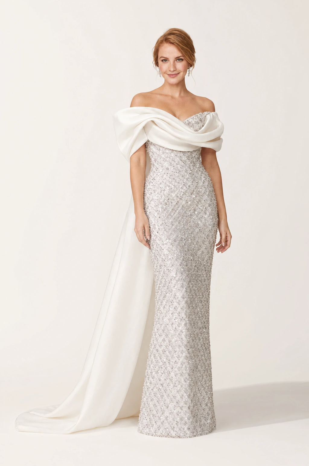 Robe bustier pailletée blanc argenté Albertine portée de face par Julie cheveux roux ondulés en chignon bas, encolure dégagée aux épaules, écharpe en satin drapée et torsadée sur les bras, bustier et jupe brodés de sequins, coupe sirène avec traîne