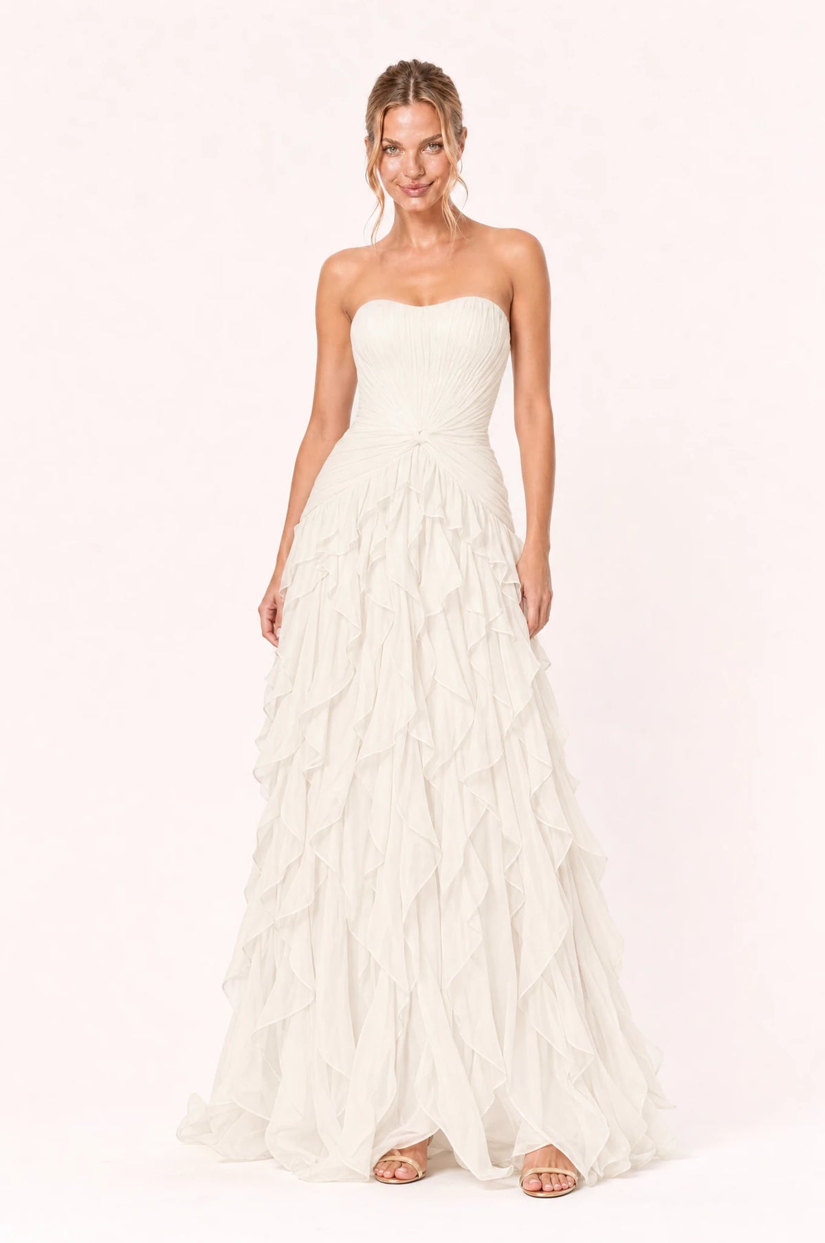 Robe bustier longue ivoire Hortense portée de face par Aude, décolleté bustier en cœur sans bretelles, bustier plissé avec nœud torsadé à la taille, jupe à volants superposés en cascade, longueur au sol