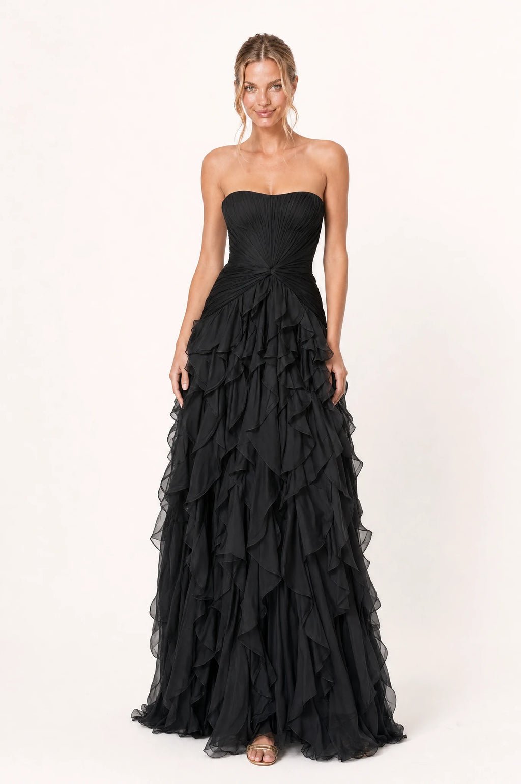 Robe bustier longue noire Hortense portée de face par Aude, décolleté bustier en cœur sans bretelles, bustier plissé avec nœud torsadé à la taille, jupe à volants superposés en cascade, longueur au sol