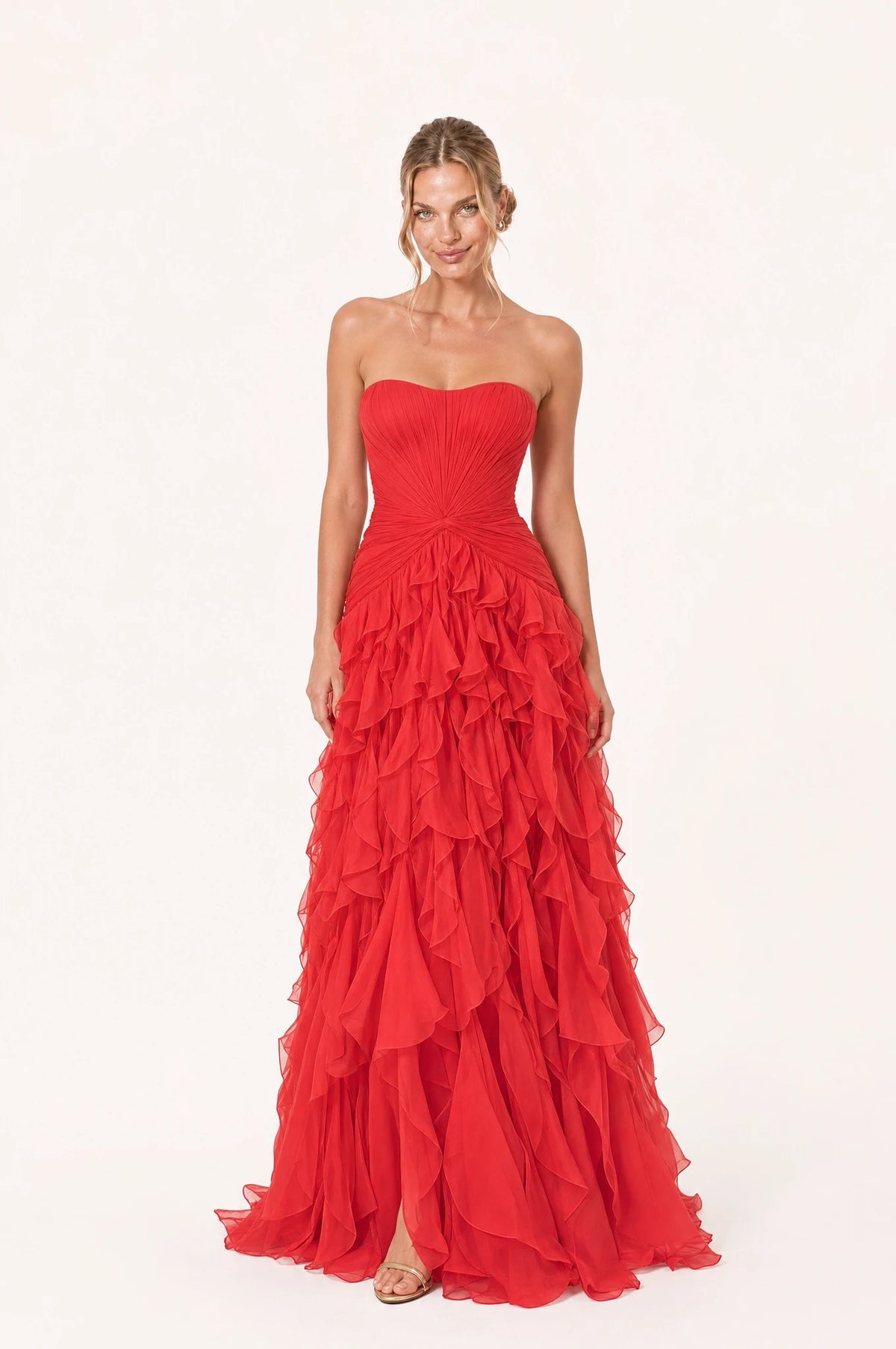 Robe bustier longue rouge Hortense portée de face par Aude chignon bas sleek, décolleté bustier en cœur sans bretelles, bustier plissé avec nœud torsadé à la taille, jupe à volants superposés en cascade, longueur au sol