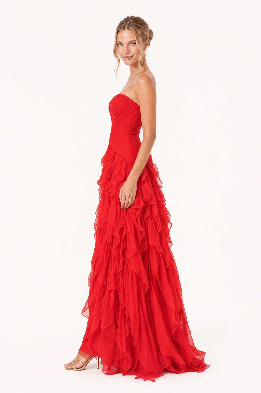 Robe bustier longue rouge Hortense vue de profil portée par Aude, bustier plissé, nœud torsadé à la taille, jupe à volants superposés en cascade, longueur au sol