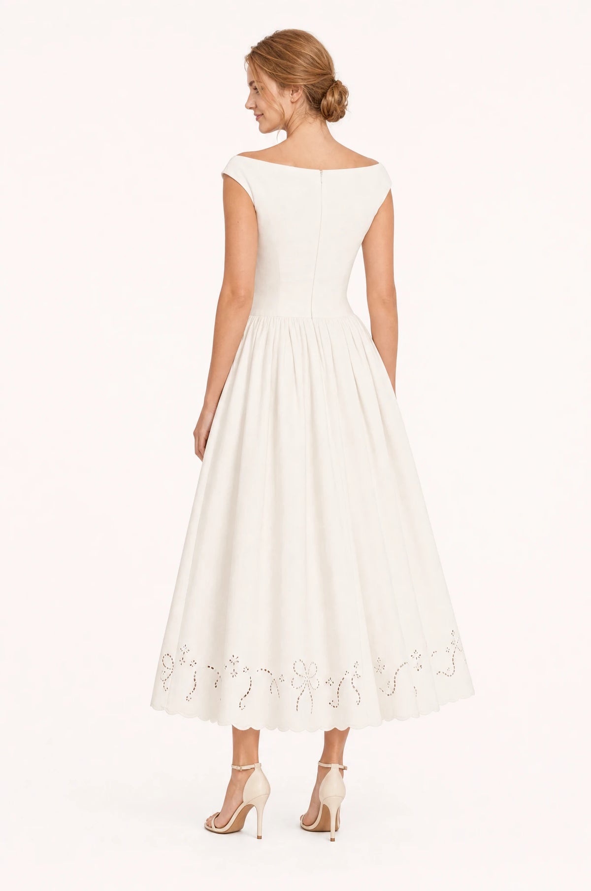 Dos de la robe chic blanche Blanche portée par Julie, décolleté bateau visible de dos, taille cintrée, jupe midi ample jusqu'à la cheville