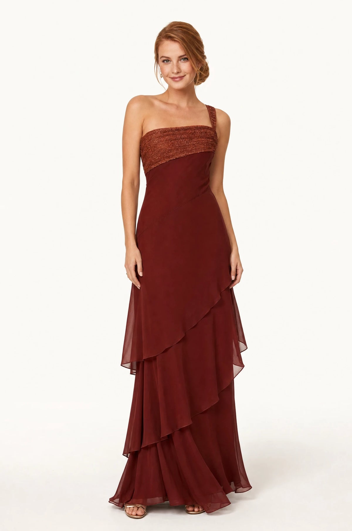 Robe chic longue bordeaux Aurore portée de face par Julie chignon bas sleek, bustier texturé rouille cuivré, bretelle asymétrique sur une épaule, jupe à volants superposés en mousseline au sol