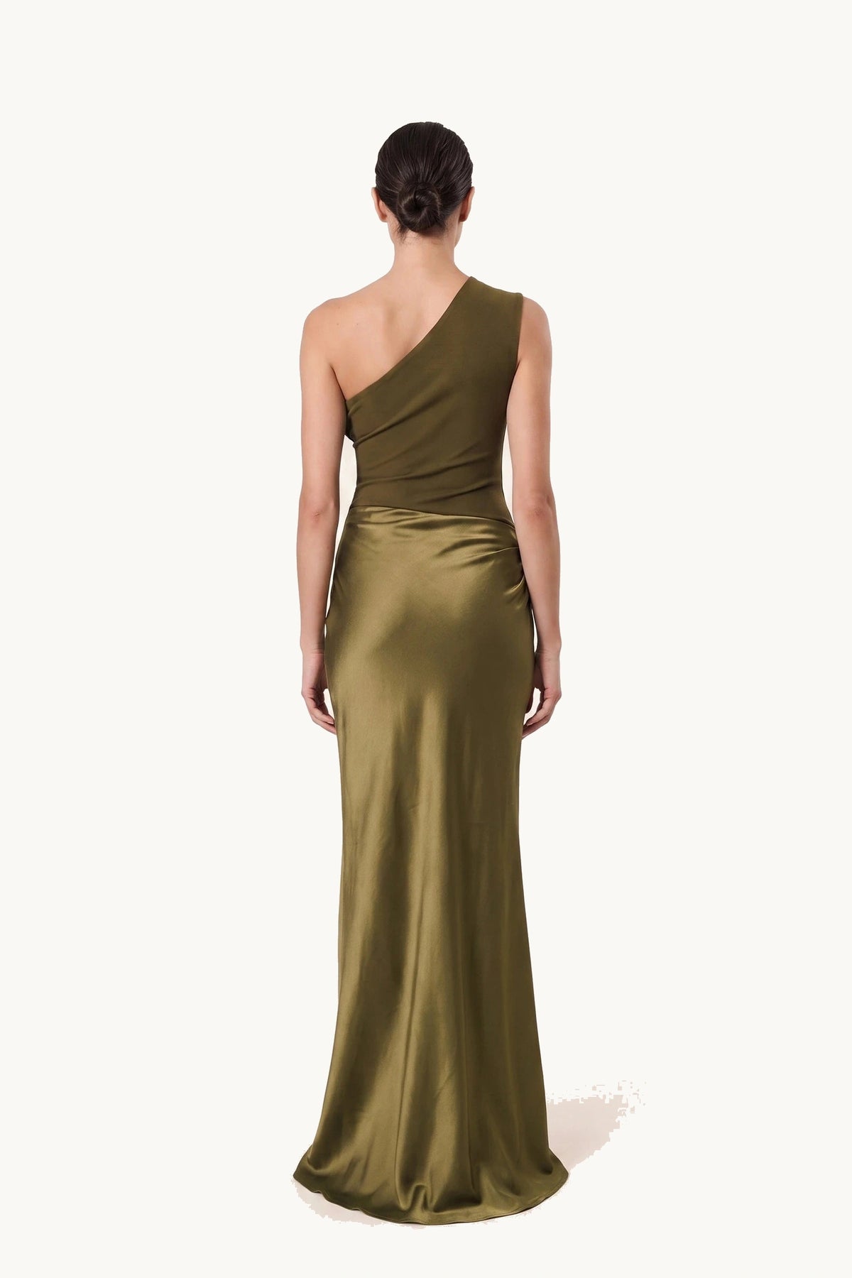 Robe chic longue Jade vert olive portée de dos sur fond neutre clair, dos asymétrique et tombé satiné