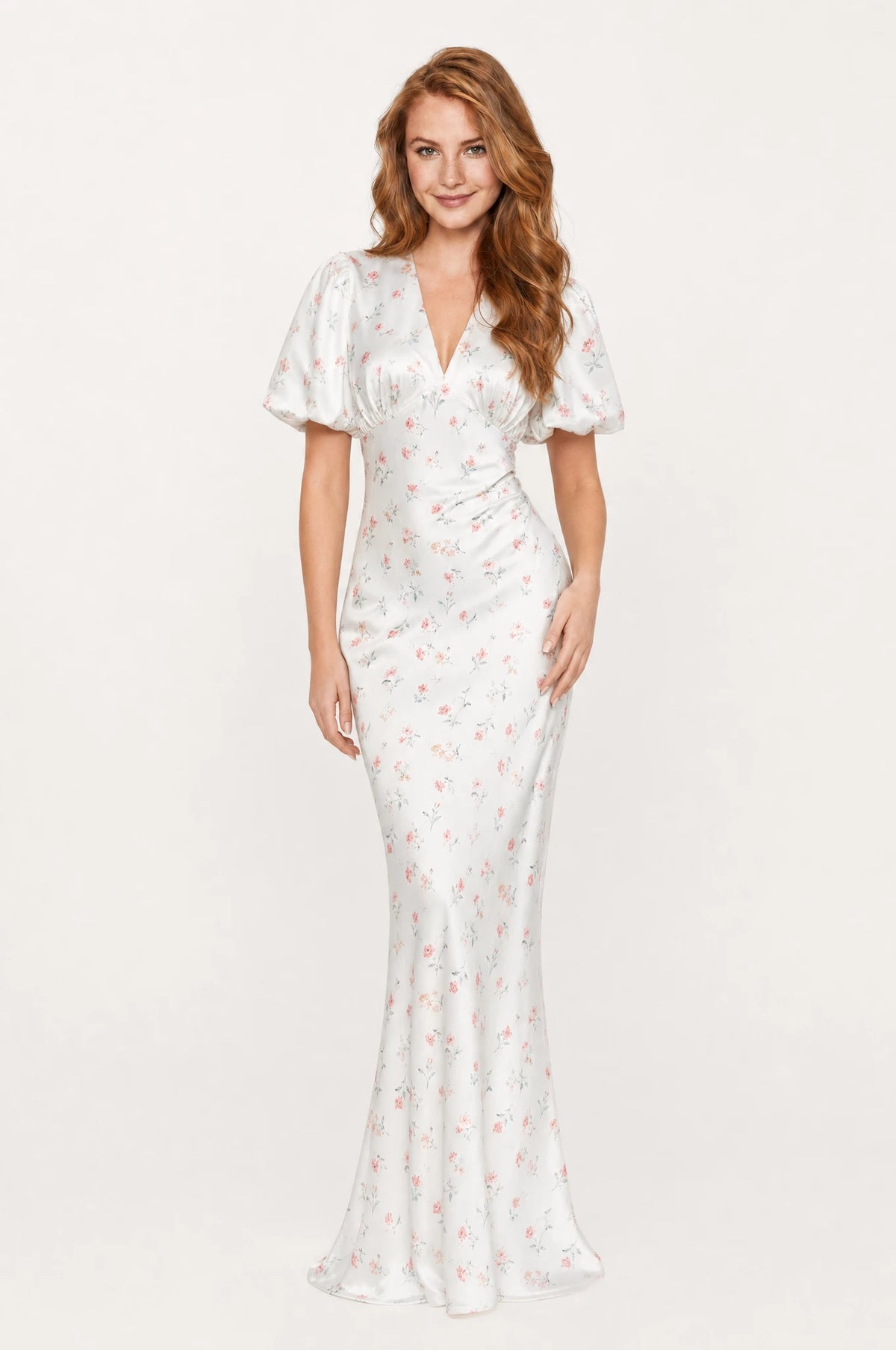 Robe cocktail blanche fleurie Aliénor portée de face par Julie cheveux roux ondulés détachés, décolleté en V profond façon cache-cœur, manches courtes bouffantes satinées, taille marquée, jupe fourreau longueur cheville légèrement évasée