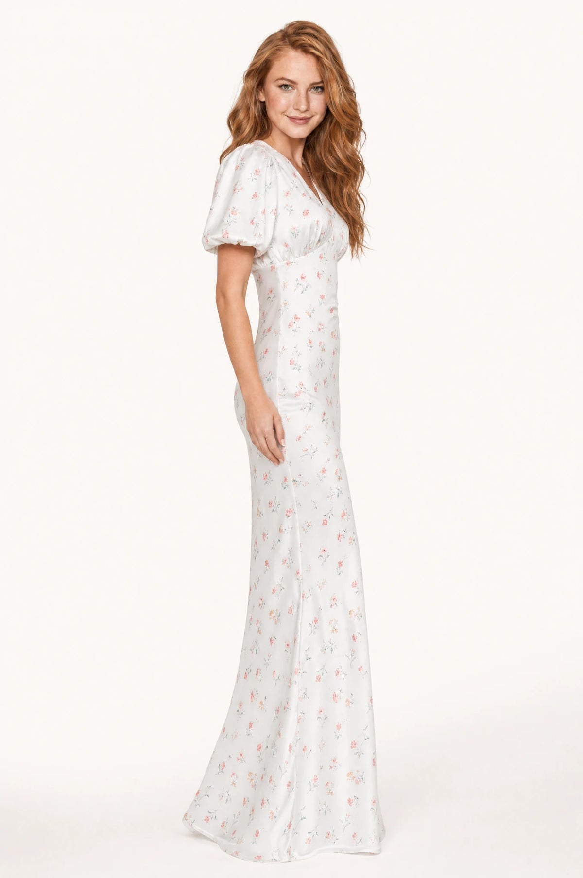 Robe cocktail blanche fleurie Aliénor vue de profil portée par Julie, taille marquée, jupe fourreau longueur cheville légèrement évasée à l'ourlet