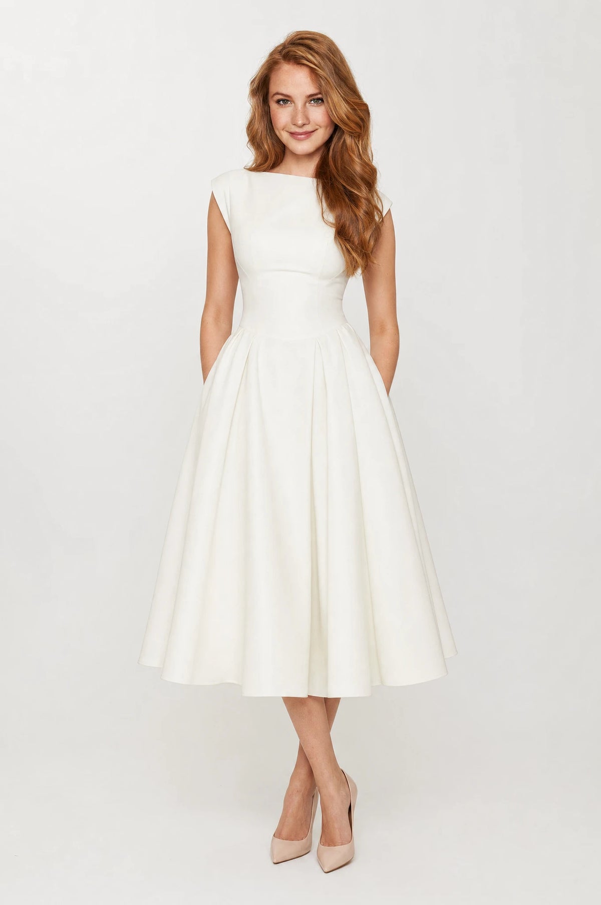 Robe cocktail blanche Charlotte portée de face par Julie cheveux roux ondulés détachés, encolure bateau structurée, larges emmanchures sans manches, taille cintrée, jupe évasée en corolle longueur mi-mollet