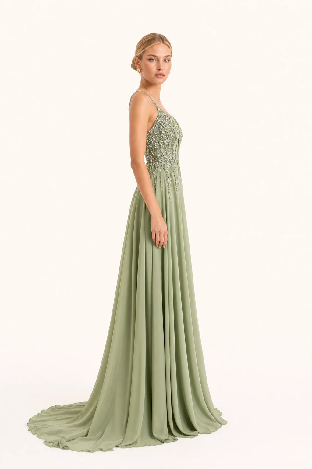Robe demoiselle d'honneur vert sauge Clémentine vue de profil portée par Sophie, bustier perlé, jupe en mousseline fluide avec traîne, longueur au sol