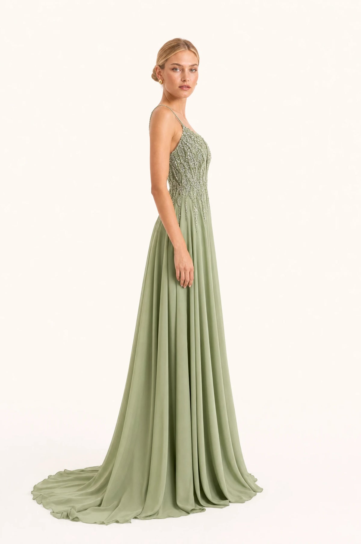 Robe demoiselle d'honneur vert sauge Clémentine vue de profil portée par Sophie, bustier perlé, jupe en mousseline fluide avec traîne, longueur au sol