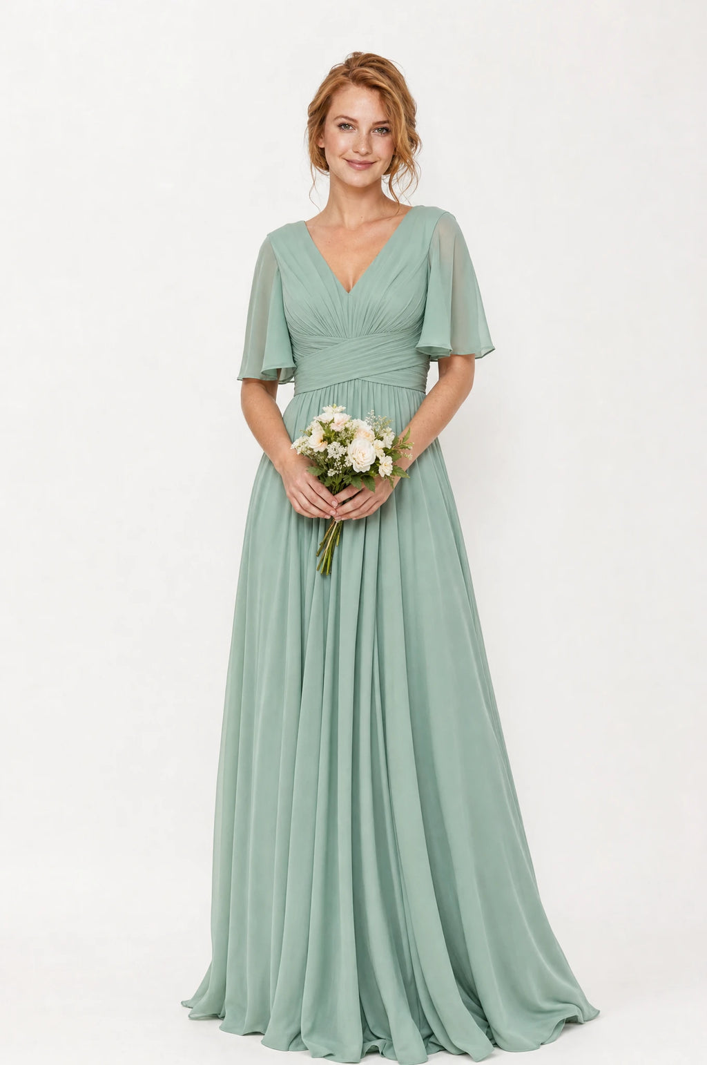 Robe demoiselle d'honneur longue fluide  vert sauge Rosalie portée de face par Julie cheveux roux ondulés, col en V, bodice plissé drapé, manches courtes évasées façon papillon, taille empire, jupe évasée fluide.